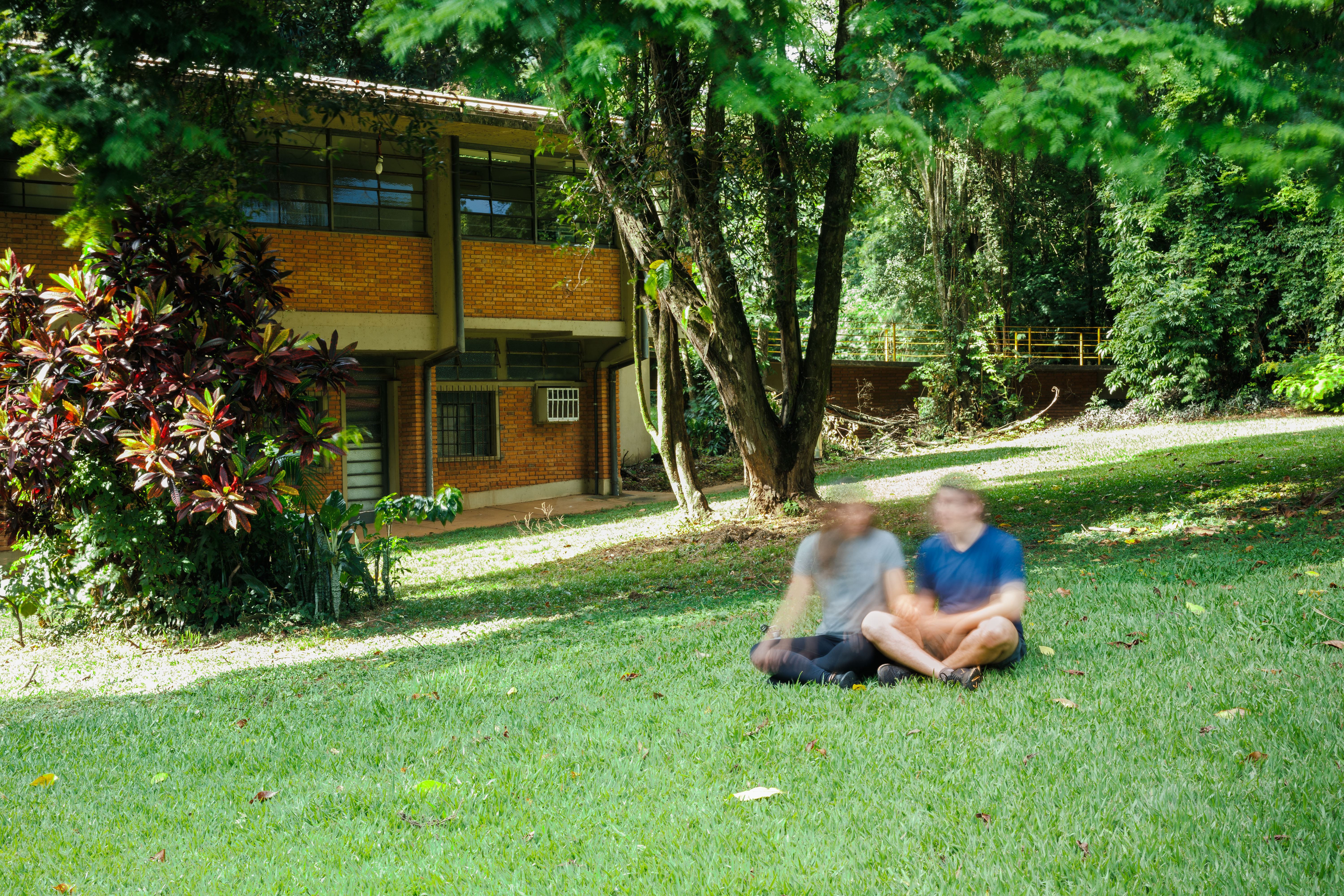 Fotografia de longa exposição de Corina e Rafael sentados em um gramado.